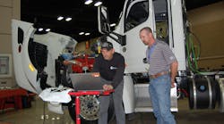Chris Zweifel (left) competes in the Cummins engine category at the 2013 Rush Truck Centers Technician Skills Rodeo under the watchful eye of contest judge Josh Washburn, a regional engine training manager for Cummins Southern Plains.