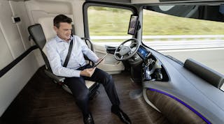 Driver of Mercedes-Benz Future Truck 2025 attends to other tasks while vehicle in self-driving mode