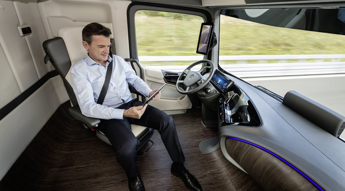 Driver of Mercedes-Benz Future Truck 2025 attends to other tasks while vehicle in self-driving mode