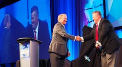 PeopleNet&apos;s Randy Boyles, left, shakes hands with Curtis Timmer, director of IT for Canadian fleet award winner Grimshaw Trucking. (Photos by Aaron Marsh)