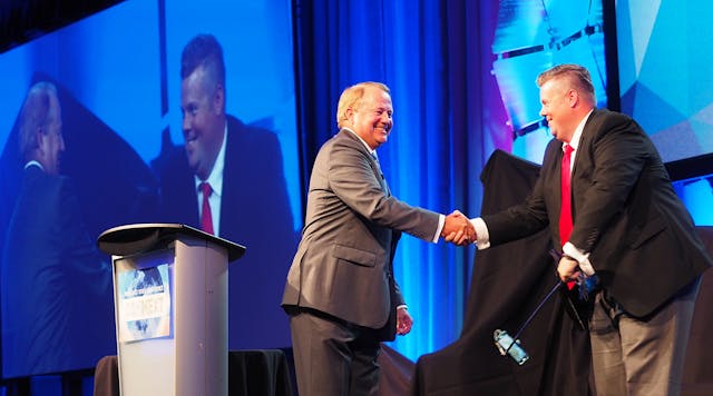 PeopleNet&apos;s Randy Boyles, left, shakes hands with Curtis Timmer, director of IT for Canadian fleet award winner Grimshaw Trucking. (Photos by Aaron Marsh)