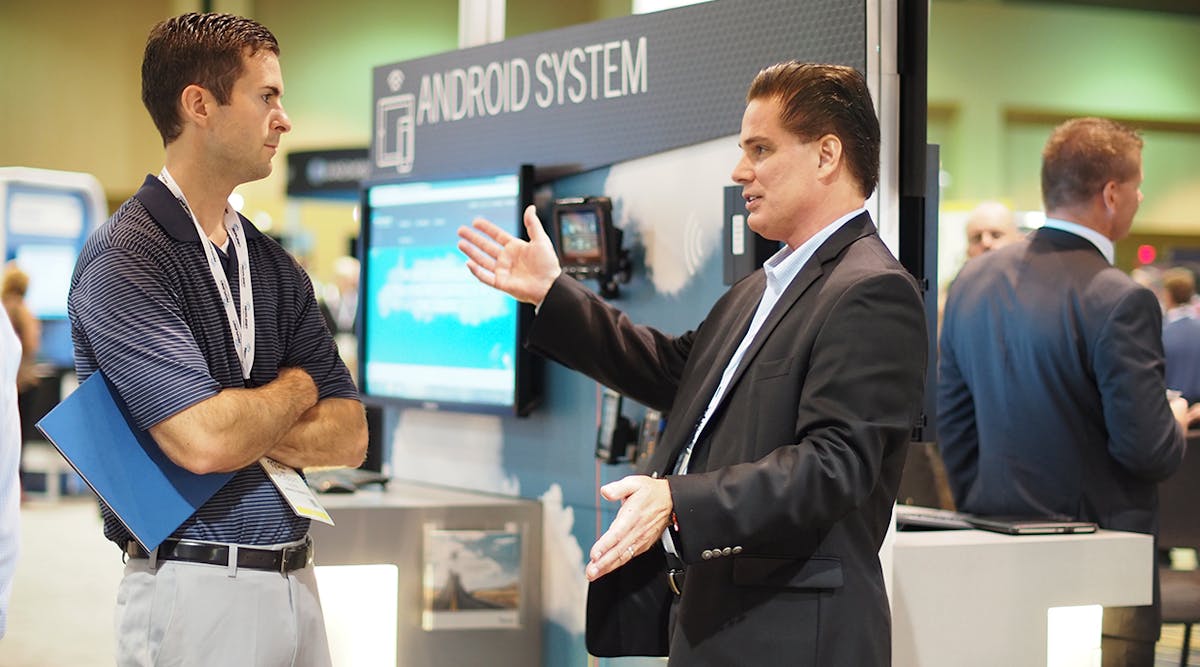 PeopleNet&apos;s Mike Nalepka (right) speaks with attendee Robert Soper at TMW Systems&apos; Transforum conference, where the two companies announced a new software integration. (Photo by Aaron Marsh)