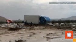 A still from Black&apos;s video on Accuweather.com shows a driver standing on his truck as flood waters swirl around it.