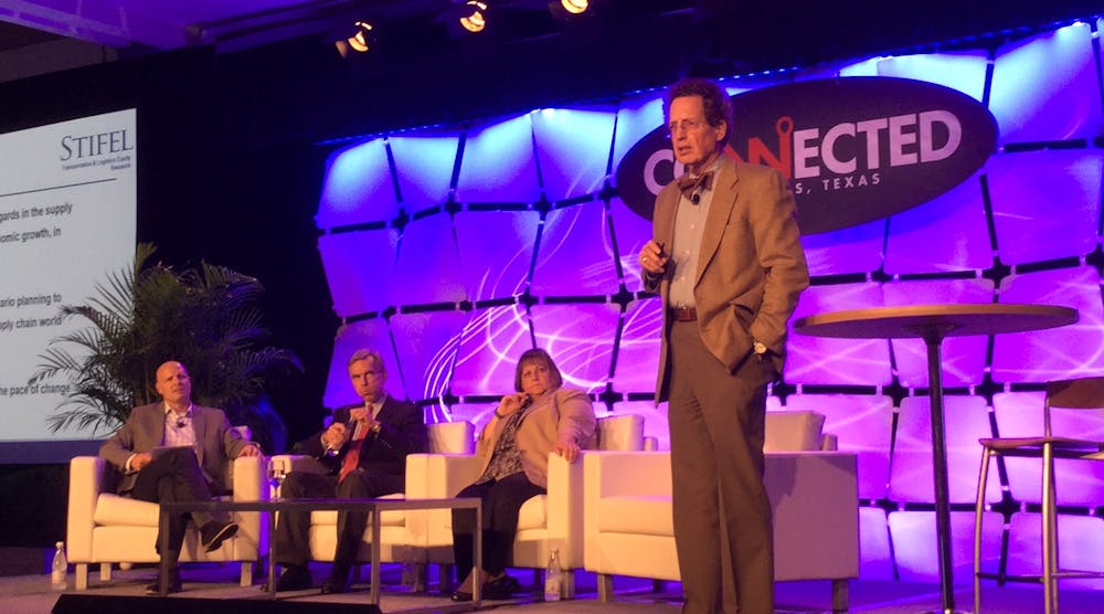 Economist No&euml;l Perry, senior consultant for FTR., speaks at Connected 2015, the Truckstop.com user conference in Dallas this week. Seated (l to r) are Internet Truckstop Group CMO Brent Hutto; Stifel Managing Director John Larkin; and NASSTRAC Exec. Dir. Gail Rutkowski.