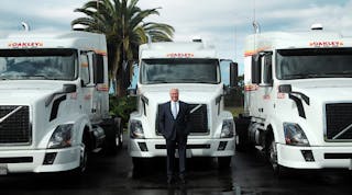Oakley Transport Inc. President and CEO Thomas E. Oakley stands in front of some of the company&apos;s Volvo VNL tractors. If you look very closely at the truck on the right, behind the tank at the side is an auxiliary power unit, or APU. (Photo courtesy Oakley Transport)