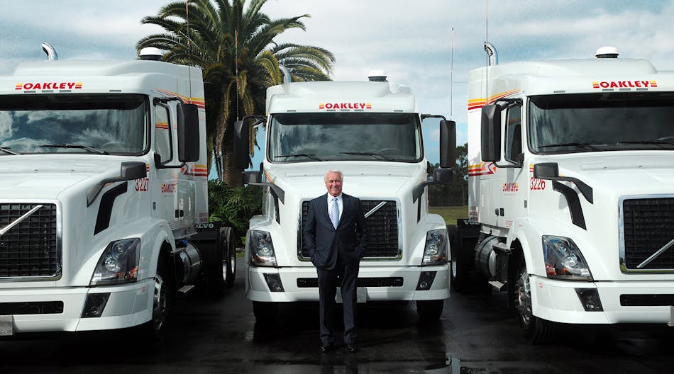 Oakley Transport Inc. President and CEO Thomas E. Oakley stands in front of some of the company&apos;s Volvo VNL tractors. If you look very closely at the truck on the right, behind the tank at the side is an auxiliary power unit, or APU. (Photo courtesy Oakley Transport)
