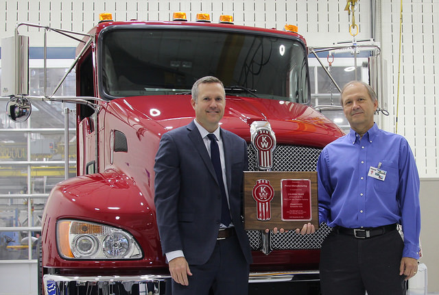 Jason Skoog Kenworth assistant general manager for sales and marketing left presents a commemorative plaque and the keys to the 150000th truck ndash a new Kenworth T370 ndash built at the PACCARSteTherese plant to Rich Demski Florida division chief engineer and commercial chassis manager for Pierce Manufacturing