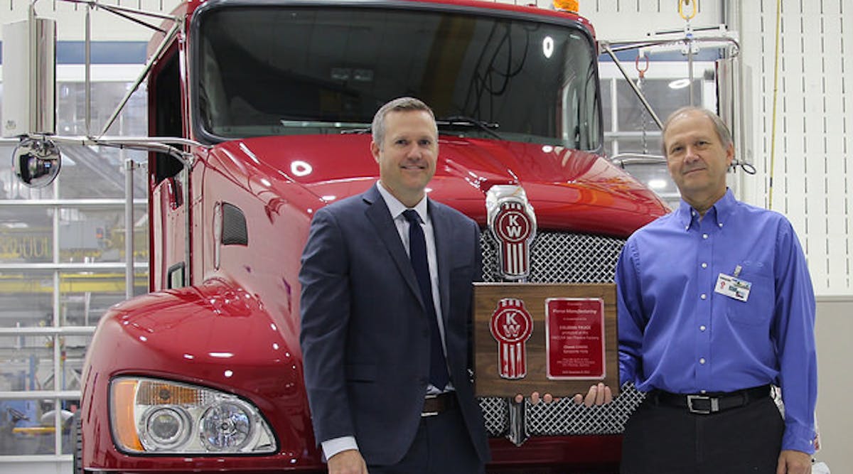 Jason Skoog, Kenworth assistant general manager for sales and marketing, left, presents a commemorative plaque and the keys to the 150,000th truck &ndash; a new Kenworth T370 &ndash; built at the PACCAR-Ste.-Therese plant to Rich Demski, Florida division chief engineer and commercial chassis manager for Pierce Manufacturing.