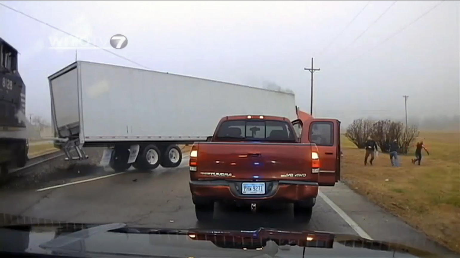 A still from the video posted by WHIOTV 7 shows the truck being hit by an oncoming train and propelled toward police offers as well as the drivers involved in an earlier accident