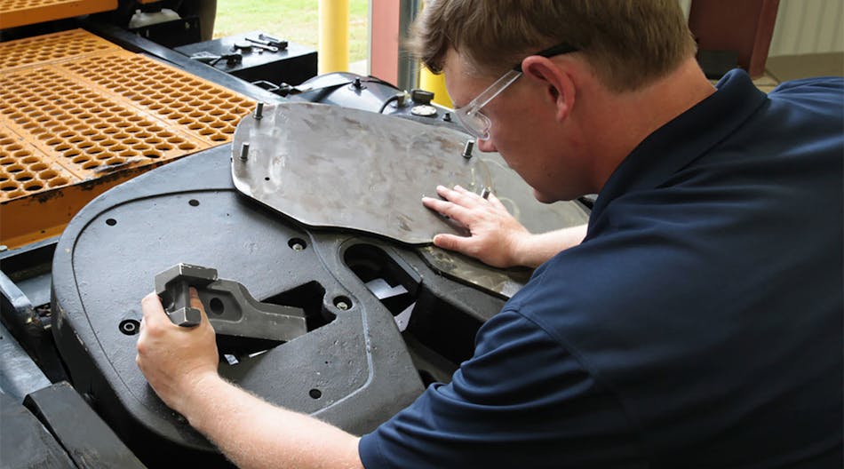 A technician removes a wear plate to rebuild the Fontaine Armor fifth wheel from the top side.