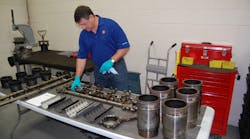 Shell&apos;s Dan Arcy examining engine components following teardown testing conducted two years ago as part of the company&apos;s PC-11 development process. (Photo by Sean Kilcarr/Fleet Owner)