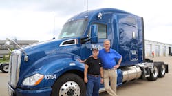Melton Truck Lines Chairman and CEO Bob Peterson (far right) stands next to one of the flatbed carrier&apos;s million mile drivers, Michael Pauley. (Photo: Melton Truck Lines)