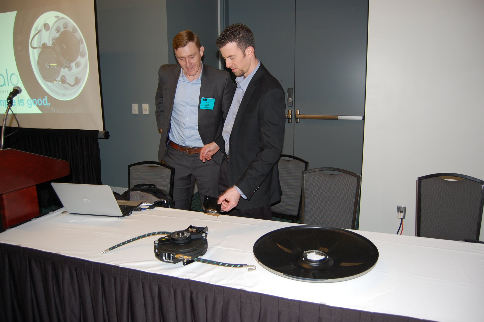 Aperia39s Josh Carter left and FlowBelow39s Josh Butler discuss the new brackets that link Aperia39s Halo Tire Inflator with FlowBelow39s wheel covers Photo by Sean Kilcarr for Fleet Owner