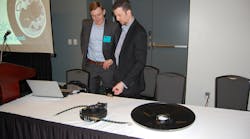 Aperia&apos;s Josh Carter (left) and FlowBelow&apos;s Josh Butler discuss the new brackets that link Aperia&apos;s Halo Tire Inflator with FlowBelow&apos;s wheel covers. (Photo by Sean Kilcarr for Fleet Owner)