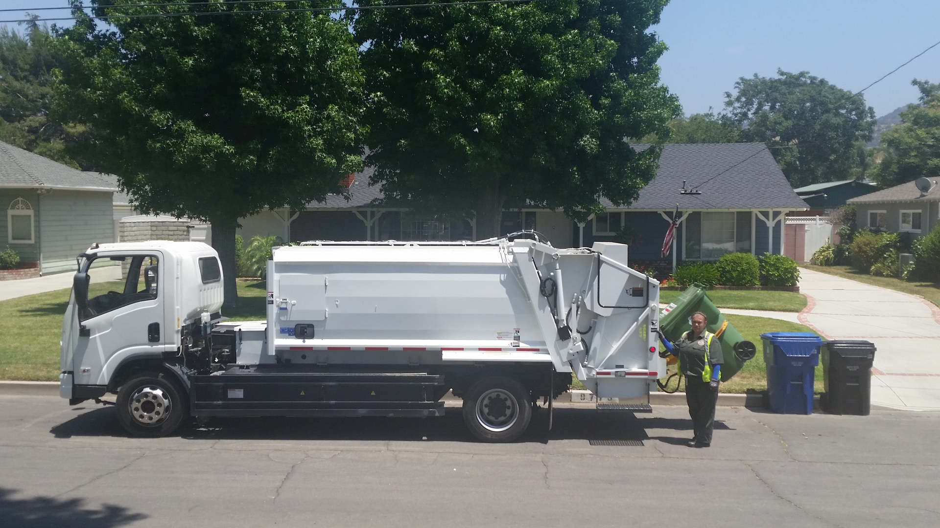 A Los Angeles sanitation worker loads trash into the back of the batteryelectric refuse truck designed and built by BYD and Wayne Engineering Photo LASAN