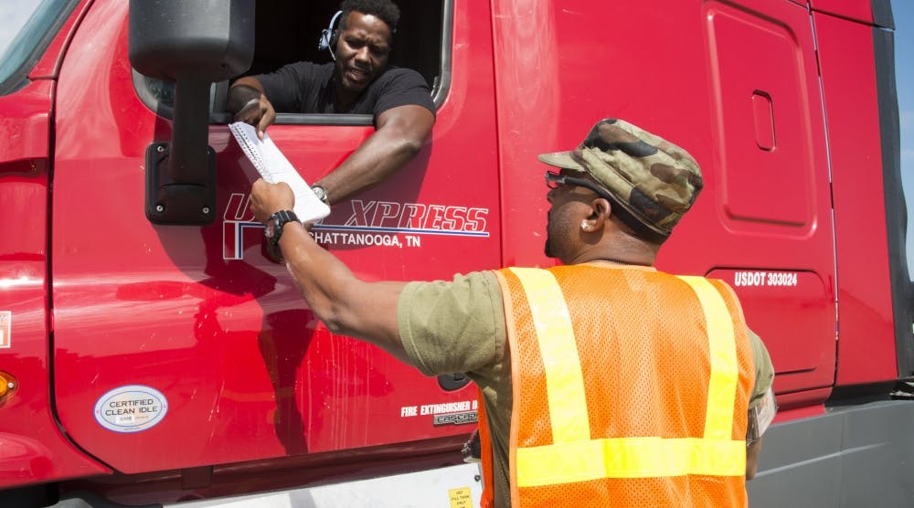 Shannon Woodyard (at right) with the Defense Logistics Agency speaks to a U.S. Xpress Enterprises truck driver preparing to pick up a load of humanitarian supplies at the San Antonio-Sequin Auxiliary Air Field in Texas in support of Hurricane Harvey disaster relief efforts. (U.S. Air Force photo by Sean M. Worrell)