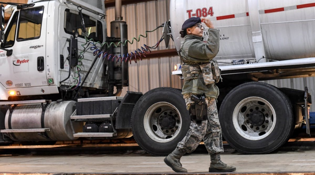 Airman 1st Class Perla Carrillo, 2nd Security Forces Squadron installation inspector, motions a truck forward for inspection at the search pit at Barksdale Air Force Base, LA.