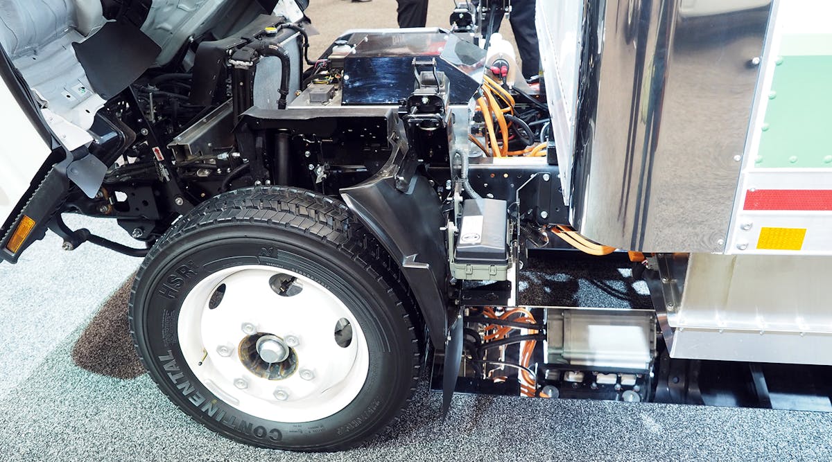 Isuzu&apos;s battery-electric NPR-HD with the cab tipped forward for a view of the electric motor.