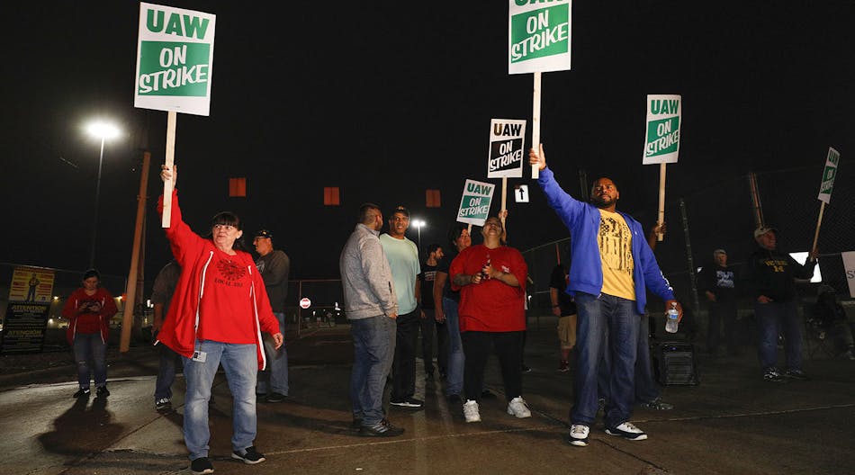 Striking UAW members picket at a gate at the General Motors Flint Assembly Plant.