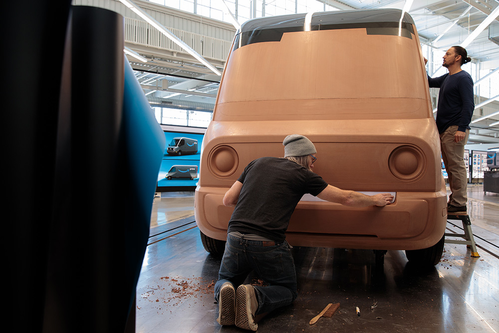 Sculptors smoothing the edges of full-size clay vehicle models of Rivian's future Amazon electric delivery vans, which are being designed in Plymouth, Mich.