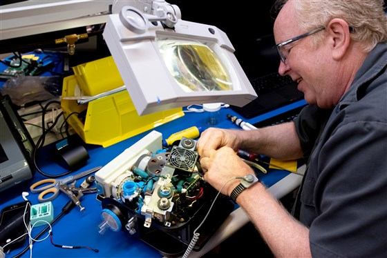 A Ventec Life Systems worker operates on a VOCSN machine, which combines the work of five respiratory medical devices into one.
