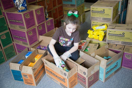 Carlisle Girl Scout Abby Hugen, 8, packs cases of cookies to donate and distribute. Carlisle Girl Scouts is holding a donation drive to give cookies to essential workers.