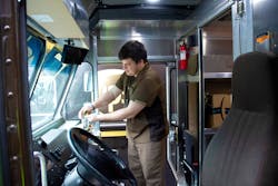 A UPS driver uses hand sanitizer. A UPS driver uses hand sanitizer.