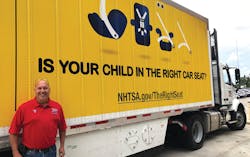 YRC Worldwide has invested in wraps to promote industry events, such as Child Passenger Safety Week. Steve Fields, a YRC Freight driver, stands by a wrapped trailer.
