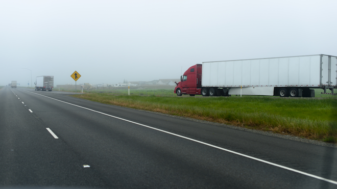 A truck enters an interstate in California, disappearing into the fog.