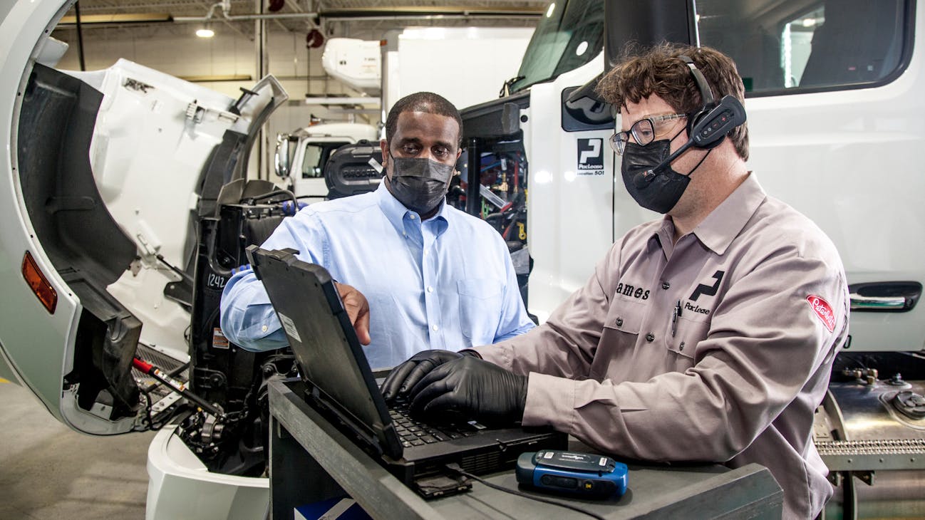 Willie Reeves, Paccar Leasing’s director of franchise maintenance, works out issues with a PacLease technician. Willie Reeves, Paccar Leasing’s director of franchise maintenance, works out issues with a PacLease technician.