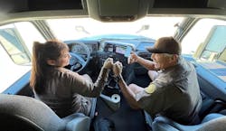 Jim and Raquel Sanchez bump fists in their cab, with Jim's 35-year patch for safe driving visible on his sleeve. Jim and Raquel Sanchez bump fists in their cab, with Jim's 35-year patch for safe driving visible on his sleeve.