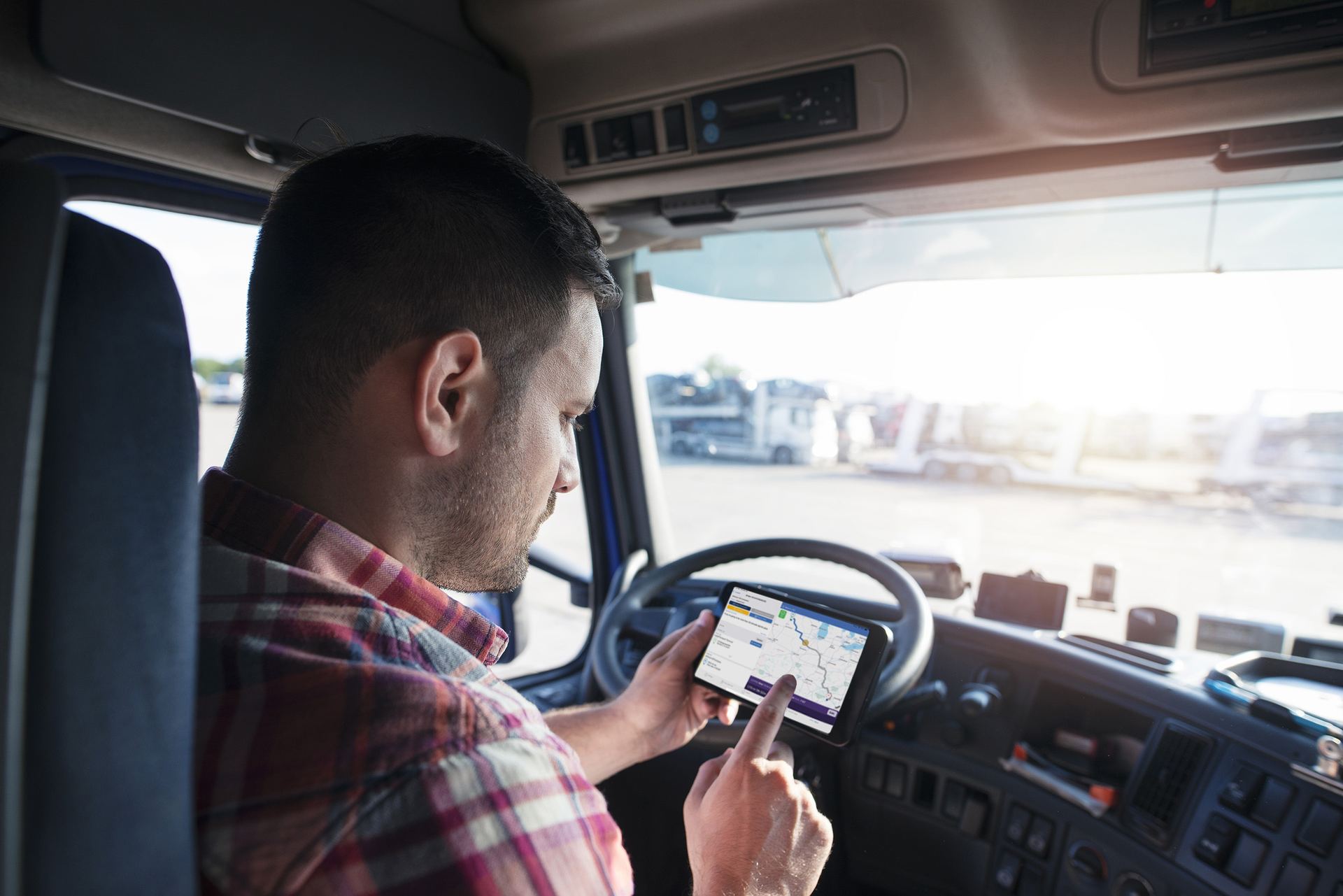 A truck driver uses an Eleos Technologies app on a smartphone. Eleos creates custom mobile apps for trucking companies to tailor the work experience for their drivers.
