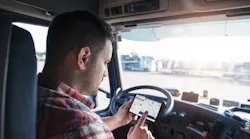 A truck driver uses an Eleos Technologies app on a smartphone. Eleos creates custom mobile apps for trucking companies to tailor the work experience for their drivers.
