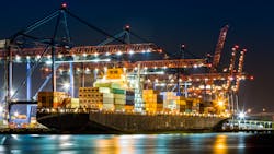 A cargo ship loaded in New York container terminal at night. A cargo ship loaded in New York container terminal at night.