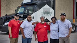 Drivers for Standard Logistics post in front of a fleet tractor. Drivers for Standard Logistics post in front of a fleet tractor.