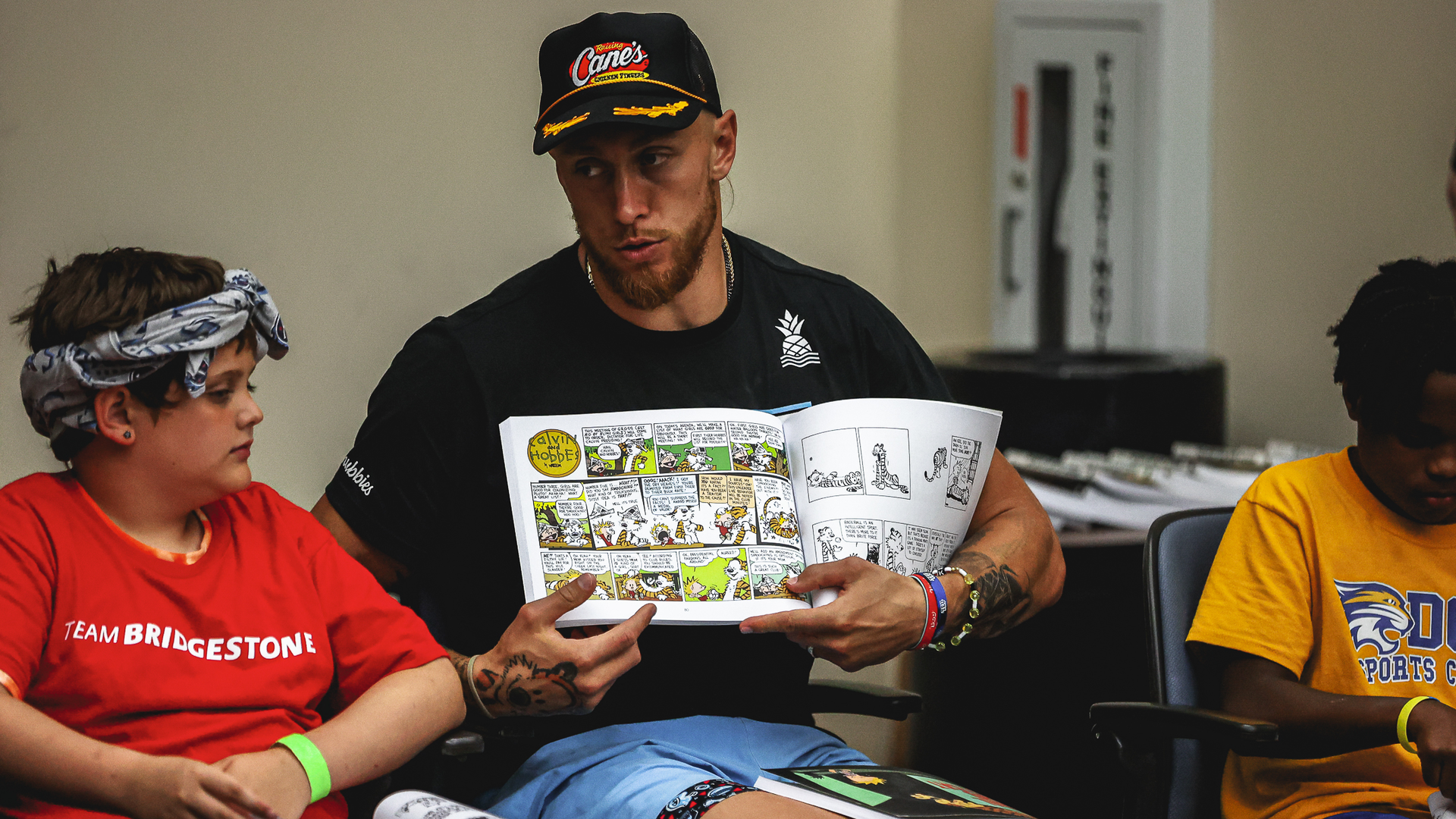 George Kittle, tight end for the San Francisco 49ers, reads to kids during a literacy program in partnership with Bridgestone during the TEU Summit 2023