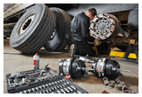 mechanic works with brake in truck repair shop