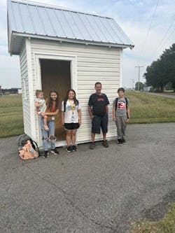 XPO maintenance specialist John Northcutt poses in front the bus hut he and his fellow employees built to keep children out of the road while they wait on Searcy buses to pick them up each morning. XPO maintenance specialist John Northcutt poses in front the bus hut he and his fellow employees built to keep children out of the road while they wait on Searcy buses to pick them up each morning.