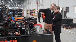 Orange EV co-founder Kurt Neutgens shows Kansas Gov. Laura Kelly an Orange EV chassis on the production line.