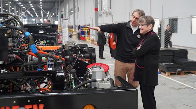 Orange EV co-founder Kurt Neutgens shows Kansas Gov. Laura Kelly an Orange EV chassis on the production line.
