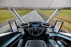 The cab of the Kenworth SuperTruck 2 features a center driving position with lower windows for visibility.