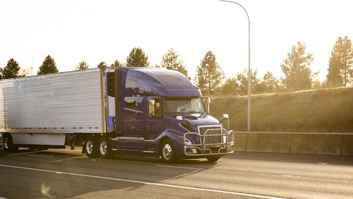 A reefer trailer is hauled on a highway on a sunny summer day.