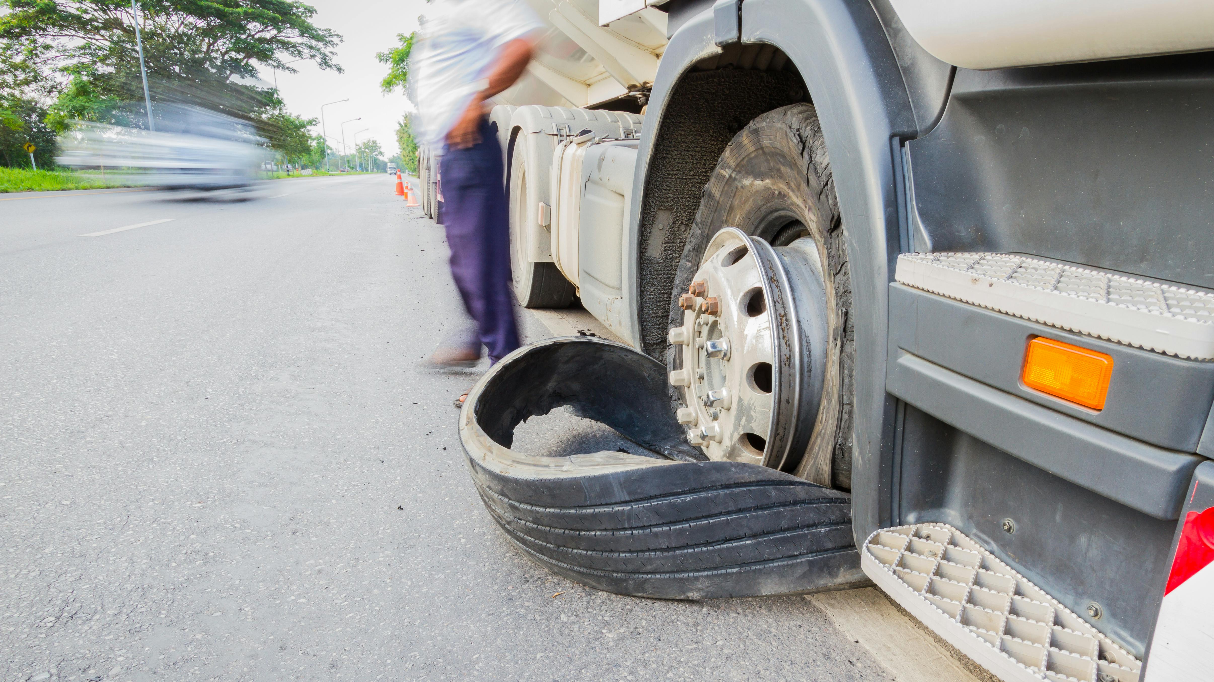 A semi truck with a failed tire tread causes a roadside breakdown.