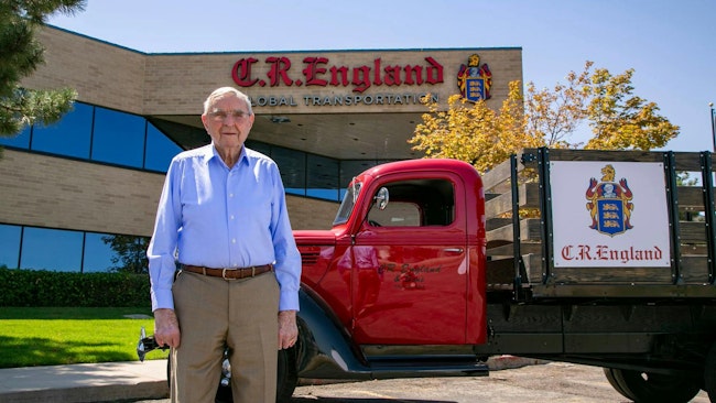 G.E. “Gene” England stands with a vintage C.R. England truck outside the fleet's Salt Lake City headquarters in 2023.