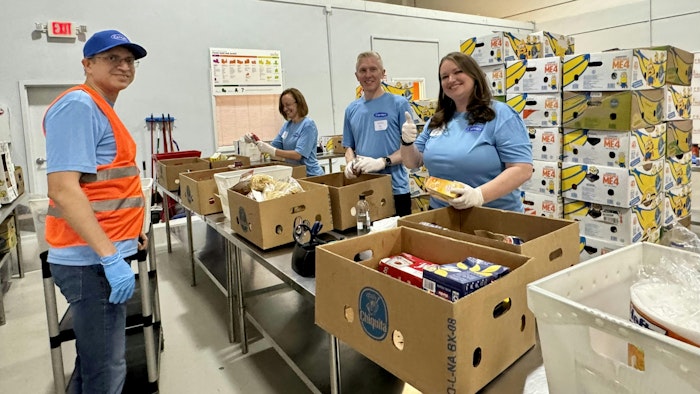 Edward Dryden, Carrier Refrigeration president, at center, and members of his leadership team volunteer by sorting and packing food at a local food bank.
