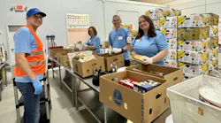 Edward Dryden, Carrier Refrigeration president, at center, and members of his leadership team volunteer by sorting and packing food at a local food bank.