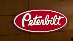 The iconic Peterbilt red oval logo on display in the OEM's Denton, Texas, corporate headquarters. The iconic Peterbilt red oval logo on display in the OEM's Denton, Texas, corporate headquarters.