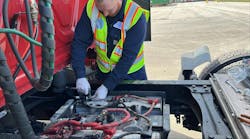 A technician installs the IdleLess hardware on a truck. A technician installs the IdleLess hardware on a truck.