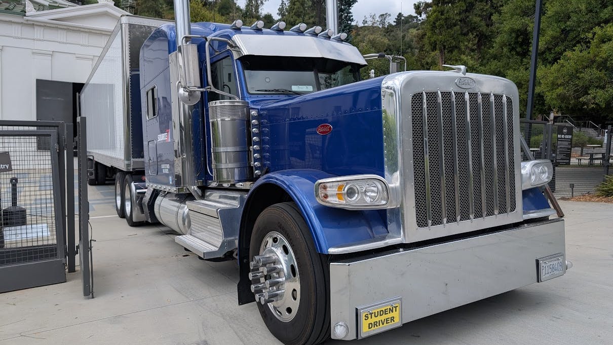 A Peterbilt 389 tractor-trailer with student driver tags unloads at the Greek Theatre in Los Angeles.