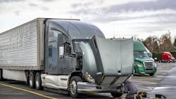 truck driver repairs a semi truck at a rest area truck driver repairs a semi truck at a rest area